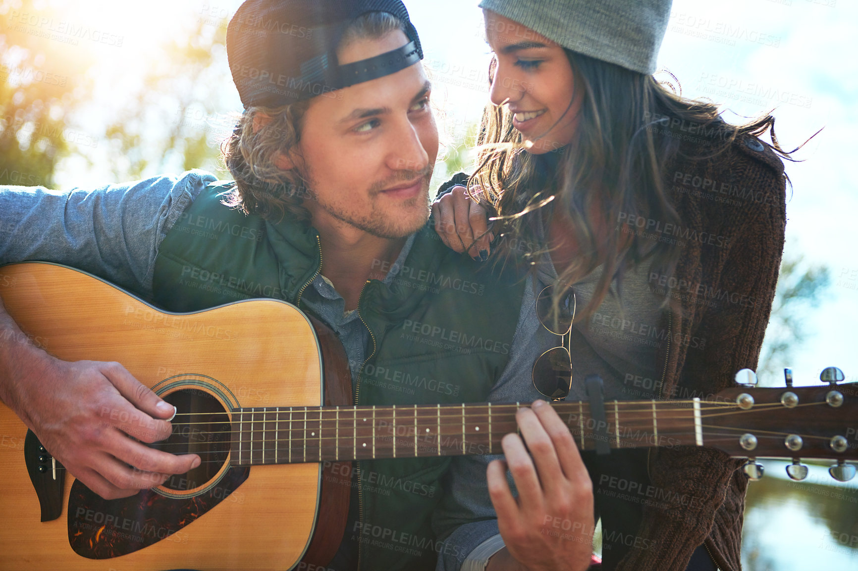 Buy stock photo Happy couple, outdoor and play guitar for love song, care and support together on vacation. String instrument, man and woman in nature for romantic music, smile and relax on holiday on valentines day