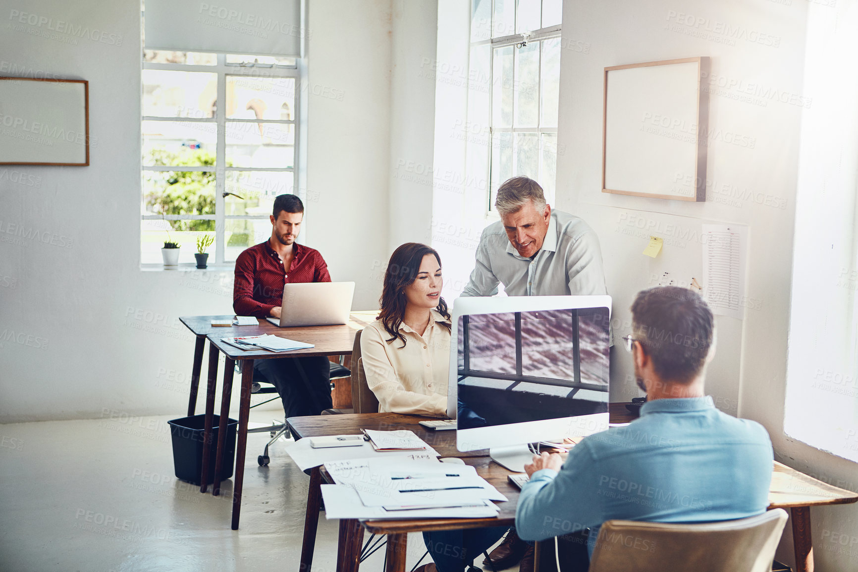 Buy stock photo Cropped shot of a group of colleagues working in their creative office