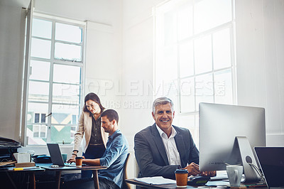 Buy stock photo Portrait, business and senior man by computer in office workplace. Pc, coworking and happy elderly male employee working on marketing report, advertising or sales project with colleagues in company.