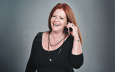 Buy stock photo Studio shot of a mature businesswoman using a mobile phone against a grey background