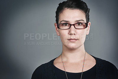 Buy stock photo Studio portrait of a confident young businesswoman posing against a grey background