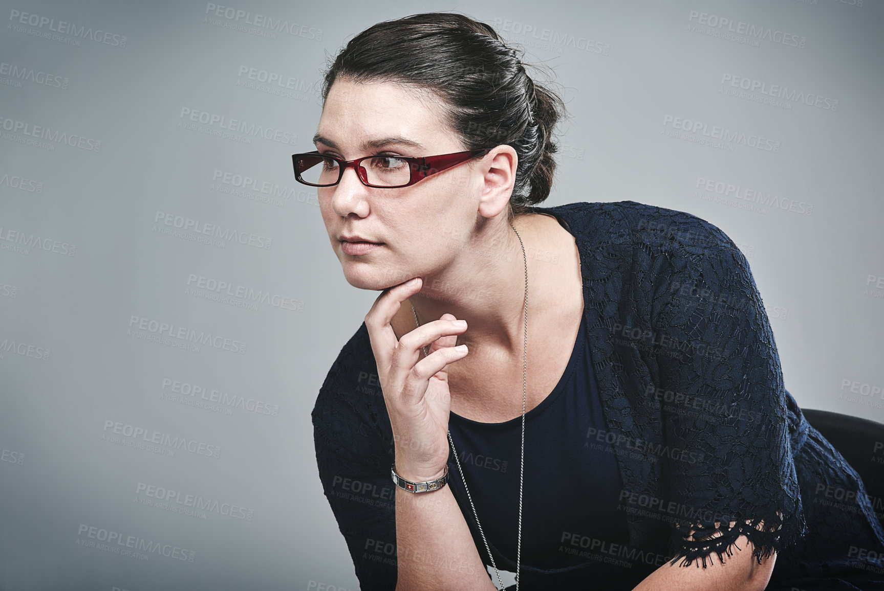 Buy stock photo Studio shot of a young businesswoman looking thoughtful against a grey background