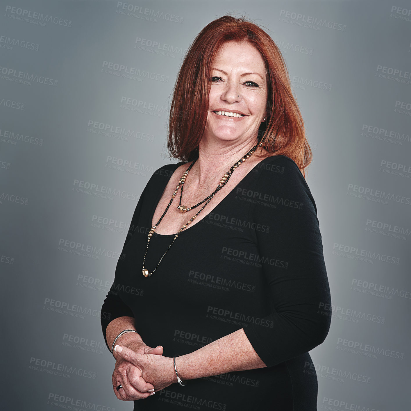 Buy stock photo Studio portrait of a happy mature businesswoman posing against a grey background