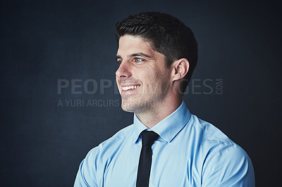 Buy stock photo Studio shot of a young businessman posing against a dark background