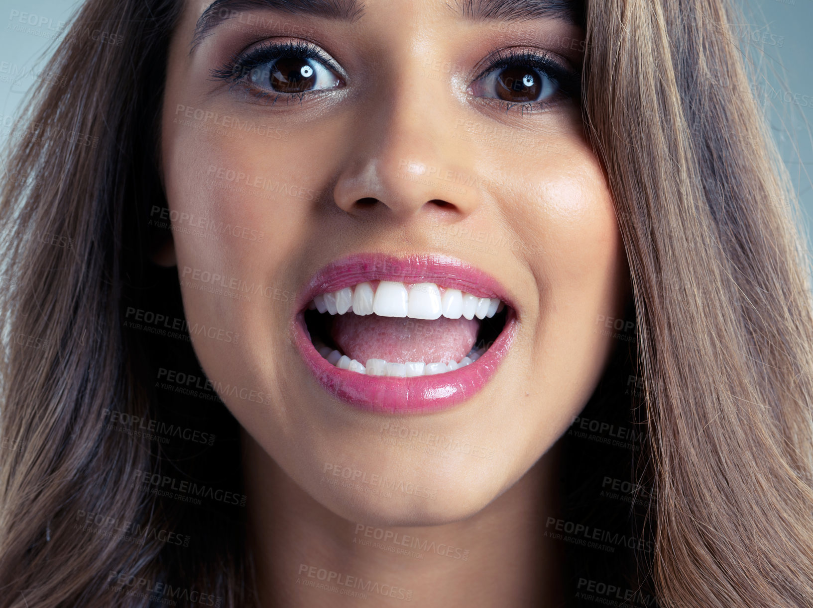 Buy stock photo Beauty, makeup and mouth with portrait of woman in studio on blue background for aesthetic wellness. Cosmetics, face and skincare with happy person at salon for dermatology, excitement or lipstick