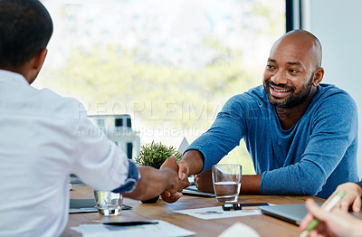 Buy stock photo Cropped shot of two young businessmen shaking hands in the office