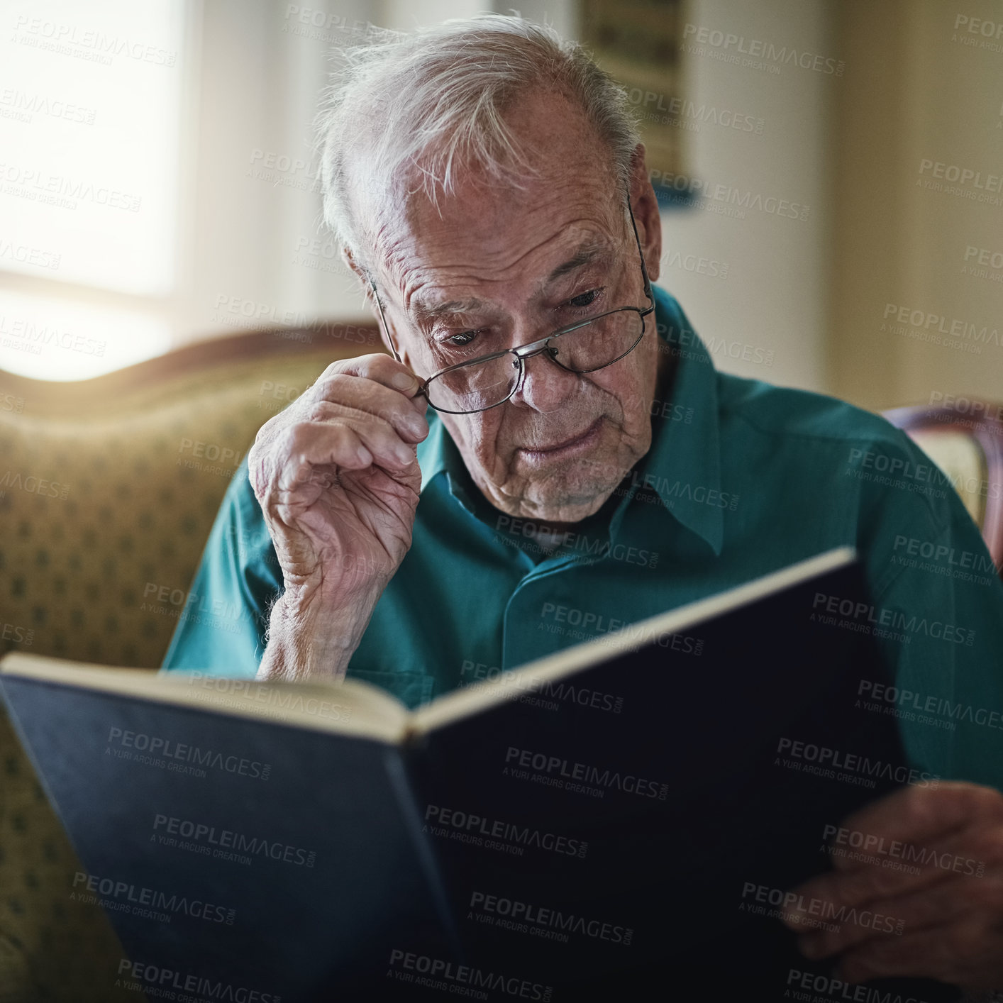 Buy stock photo Elderly man, novel and reading book in home, literature and language for learning in retirement. Old person, fiction and textbook for knowledge to relax on sofa, glasses and studying information