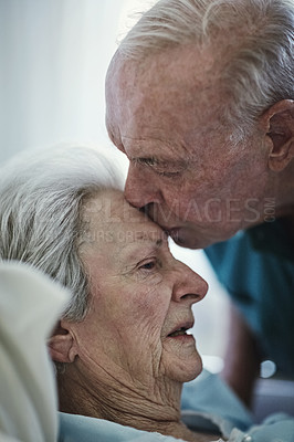 Buy stock photo Senior, kiss and couple in hospital for love, visiting sick cancer patient and hope for recovery. Clinic, elderly man and woman kissing on forehead for empathy, kindness and support for healthcare.