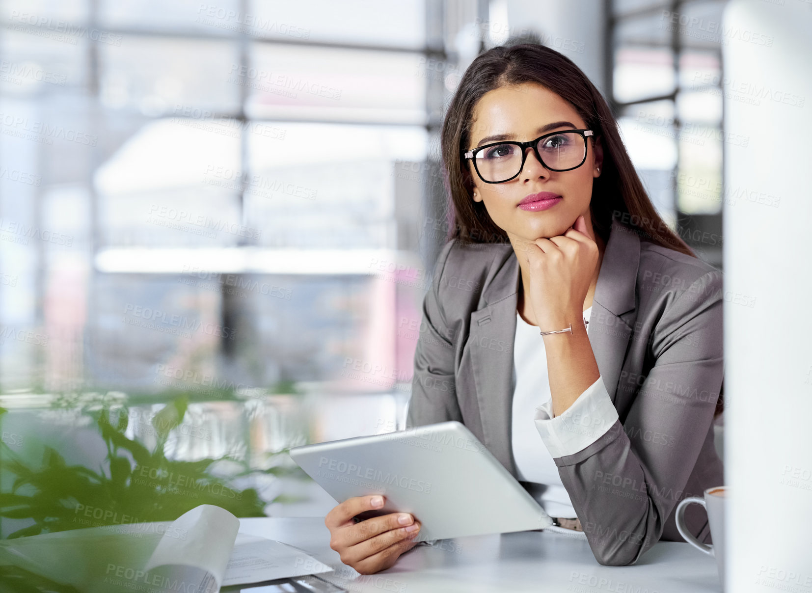 Buy stock photo Shot of a young businesswoman looking thoughtful while working in an office