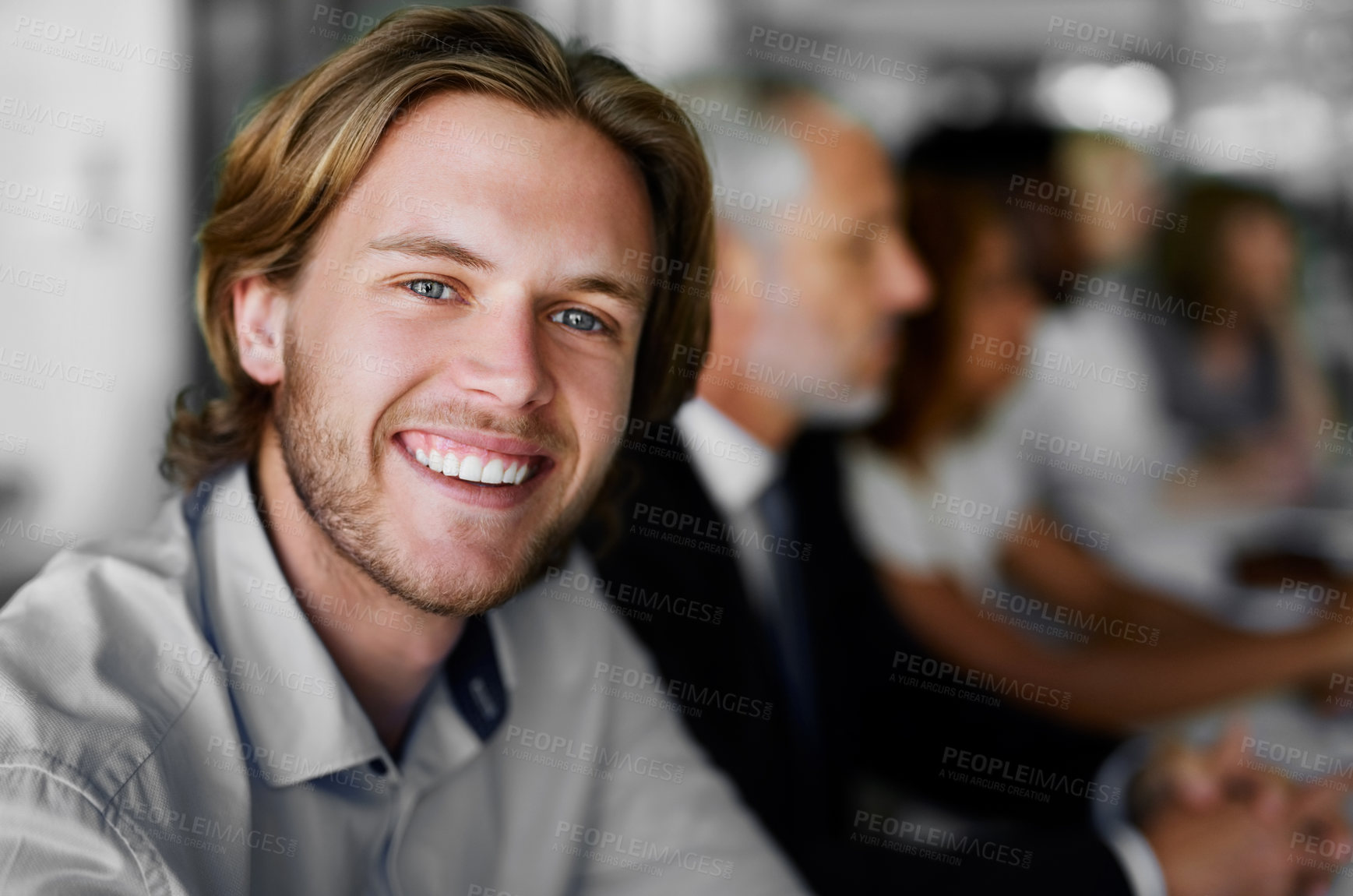 Buy stock photo Portrait of a businessman sitting in a boardroom meeting with colleagues blurred in the background