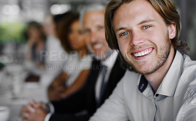 Buy stock photo Portrait of a businessman sitting in a boardroom meeting with colleagues blurred in the background