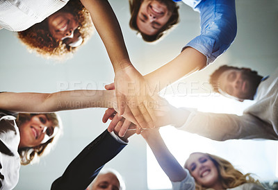 Buy stock photo Low angle shot of a group of colleagues joining their hands in solidarity