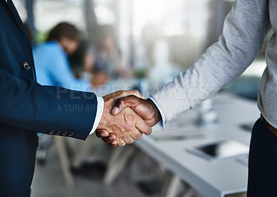Buy stock photo Cropped shot of two businessmen shaking hands during a meeting at work