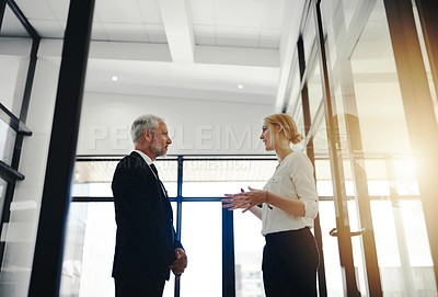 Buy stock photo Cropped shot of two businesspeople talking while standing in the office