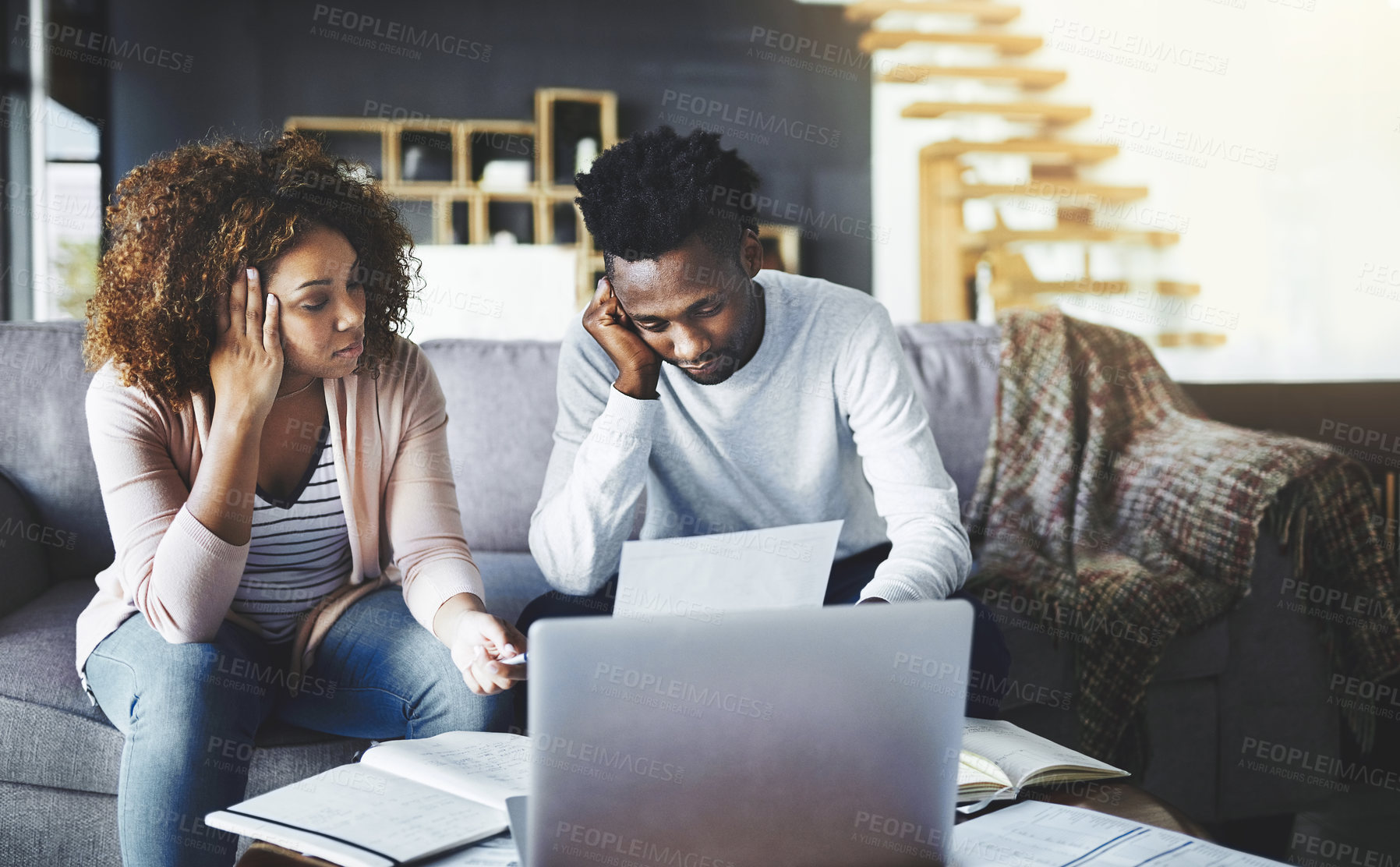 Buy stock photo Shot of a young couple looking anxious while doing their budget at home