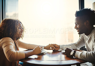 Buy stock photo In love, caring and dating young couple bonding together on a romantic date in a coffee shop or cafe. Affectionate man and woman relaxing, spending time and smiling while sitting in a restaurant