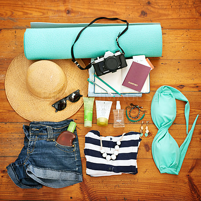Buy stock photo High angle shot of beachwear and travel paraphernalia arranged on a wooden floor