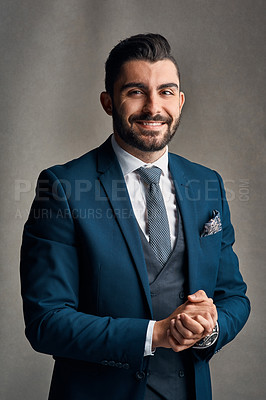 Buy stock photo Studio portrait of a stylishly dressed and happy young businessman posing against a grey background