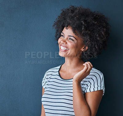 Buy stock photo Studio shot of an attractive and happy young woman posing against a blue background