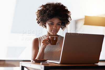 Buy stock photo Shot of a young business owner using a laptop while sitting in her cafe