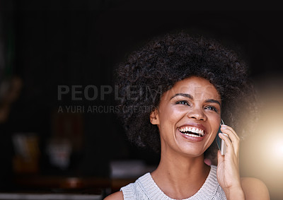 Buy stock photo Shot of a happy young business owner answering her phone while standing inside her coffee shop