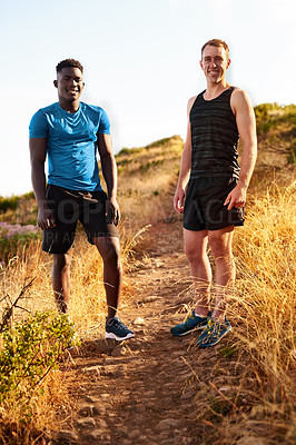 Buy stock photo Shot of two sporty young men out for a run together