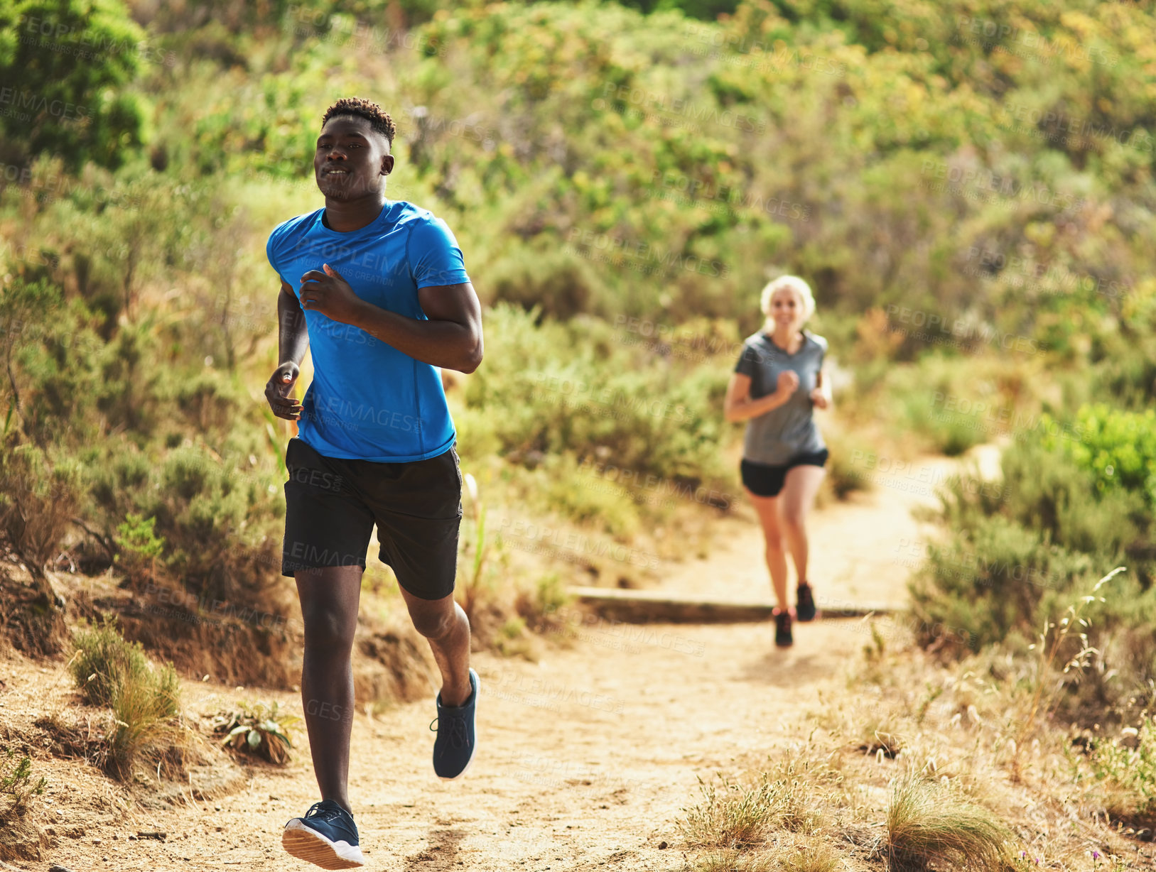 Buy stock photo Shot of two sporty young people out for a run together