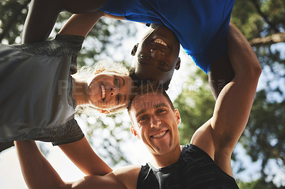 Buy stock photo Portrait of a group of sporty young people putting their heads together in a huddle