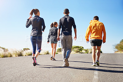Buy stock photo Rear view shot of a fitness group out for a run together