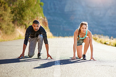 Buy stock photo Shot of a sporty young couple on their mark outside