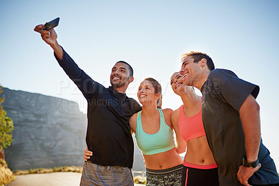 Buy stock photo Cropped shot of a fitness group taking a selfie while out for a run together