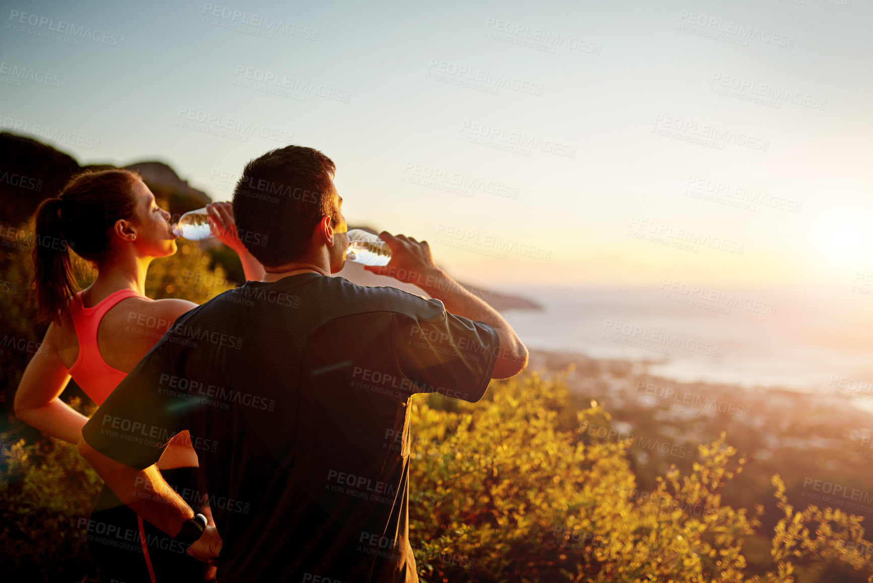 Buy stock photo Cropped shot of a sporty young couple taking a break while out for a run together