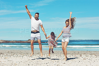 Buy stock photo Full length shot of a happy young family enjoying their day at the beach