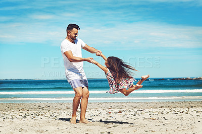 Buy stock photo Full length shot of a young father and his daughter enjoying a day at the beach