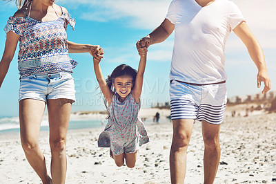 Buy stock photo Cropped shot of a happy young family enjoying their day at the beach