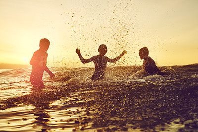 Buy stock photo Shot of three young boys having fun in the water