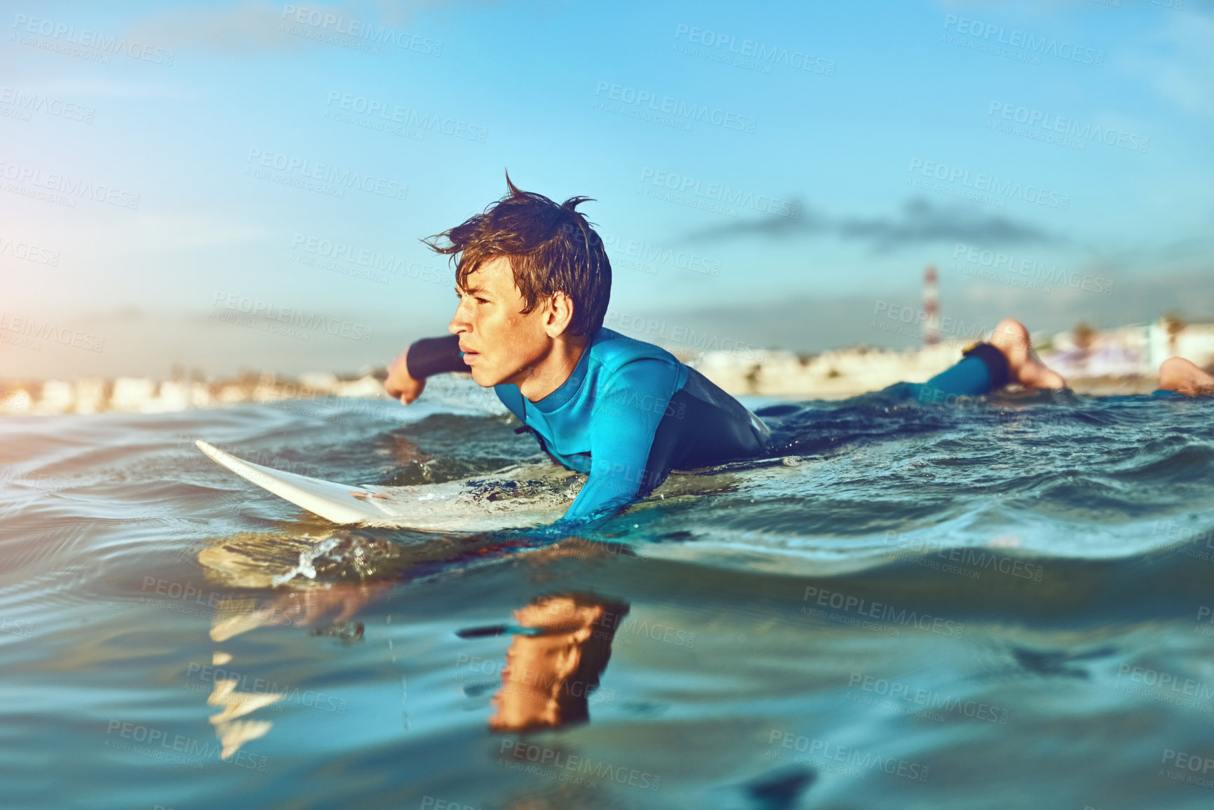 Buy stock photo Kid, waves and surfing at beach for holiday, sports and wellness with board, blue sky and swimsuit. Boy, workout and swimming stroke or surfer for learning, fitness and summer while on vacation