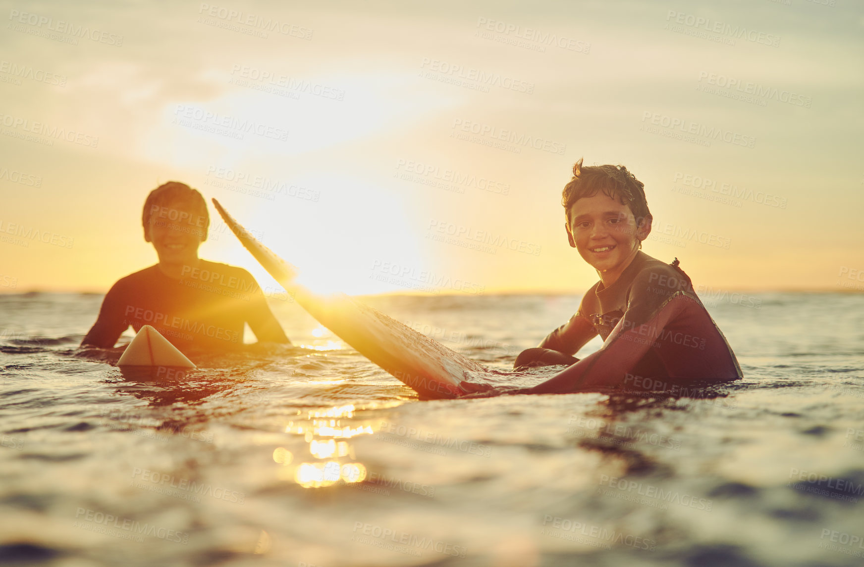 Buy stock photo Beach, portrait and boys in sea with surfboard for holiday, outdoor adventure and fun weekend together. Travel, surfing and brothers at ocean for water sports, waves and bonding vacation at sunset