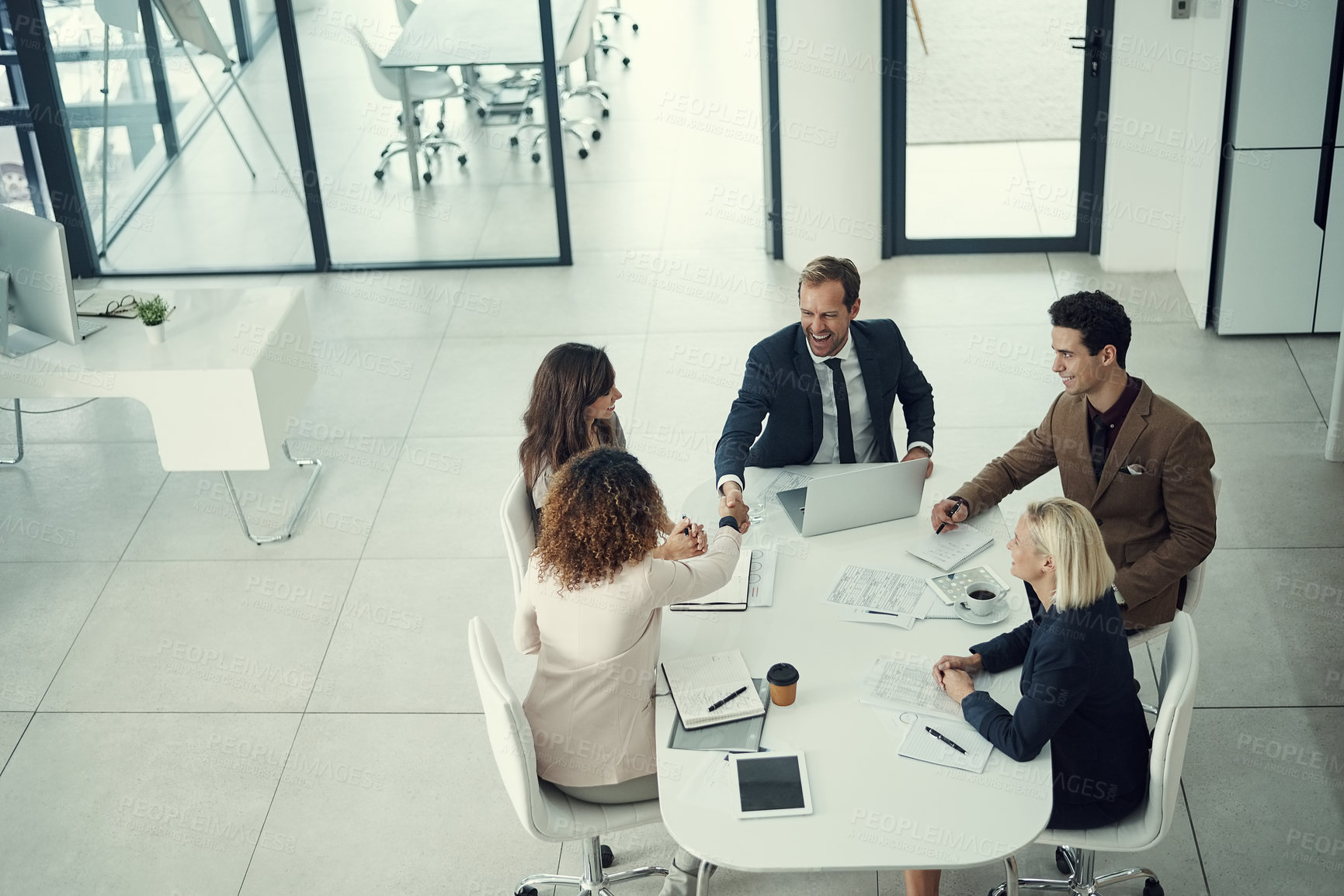 Buy stock photo Shot of a businessman and businesswoman shaking hands during a meeting in a modern office