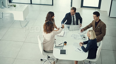 Buy stock photo Shot of a businessman and businesswoman shaking hands during a meeting in a modern office