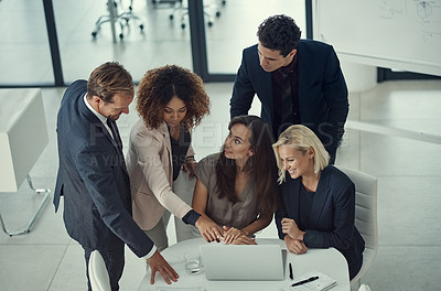 Buy stock photo Shot of a group of colleagues using laptop together during a meeting in a modern office