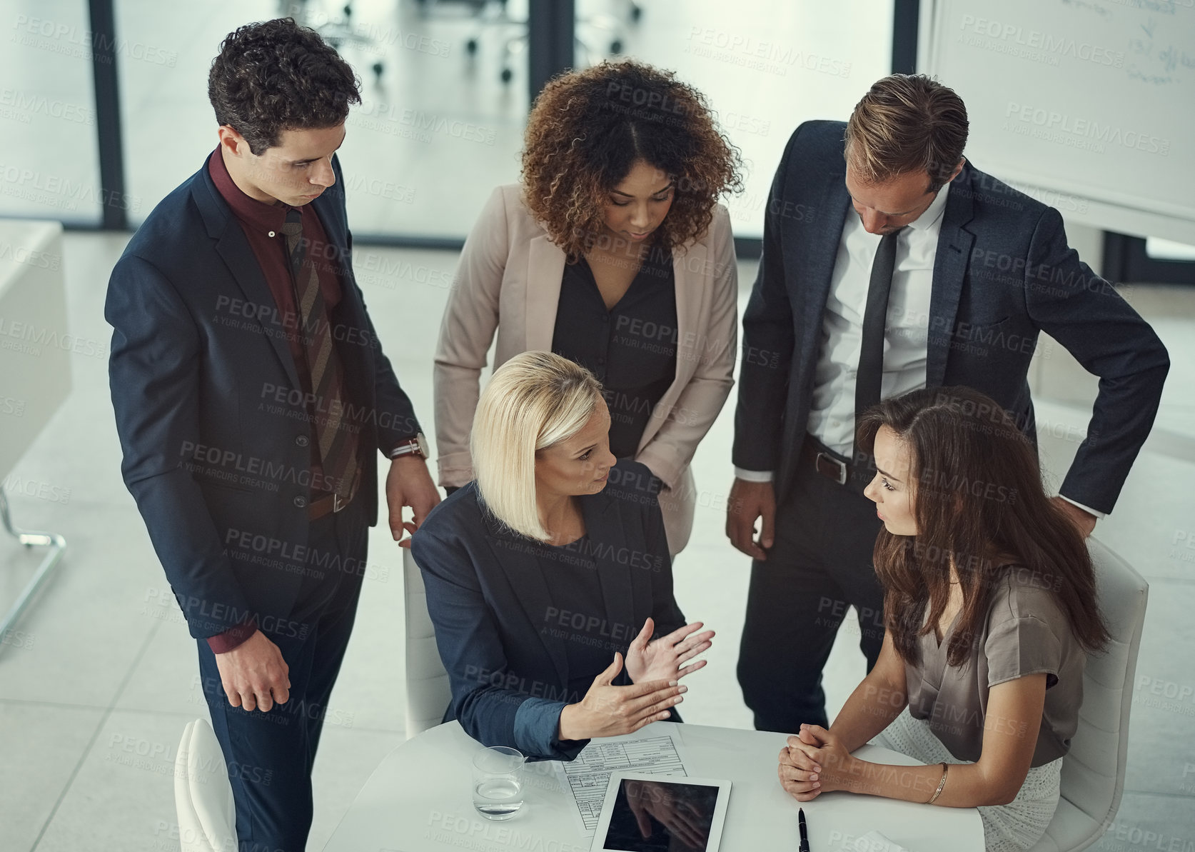 Buy stock photo Shot of a group of colleagues collaborating on a project in a modern office