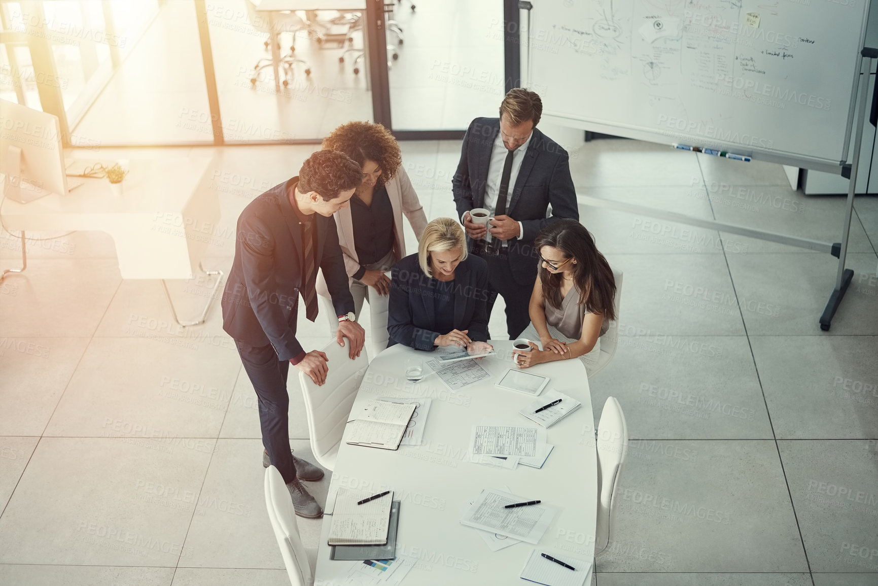 Buy stock photo Shot of a group of colleagues using digital tablet together during a meeting in a modern office