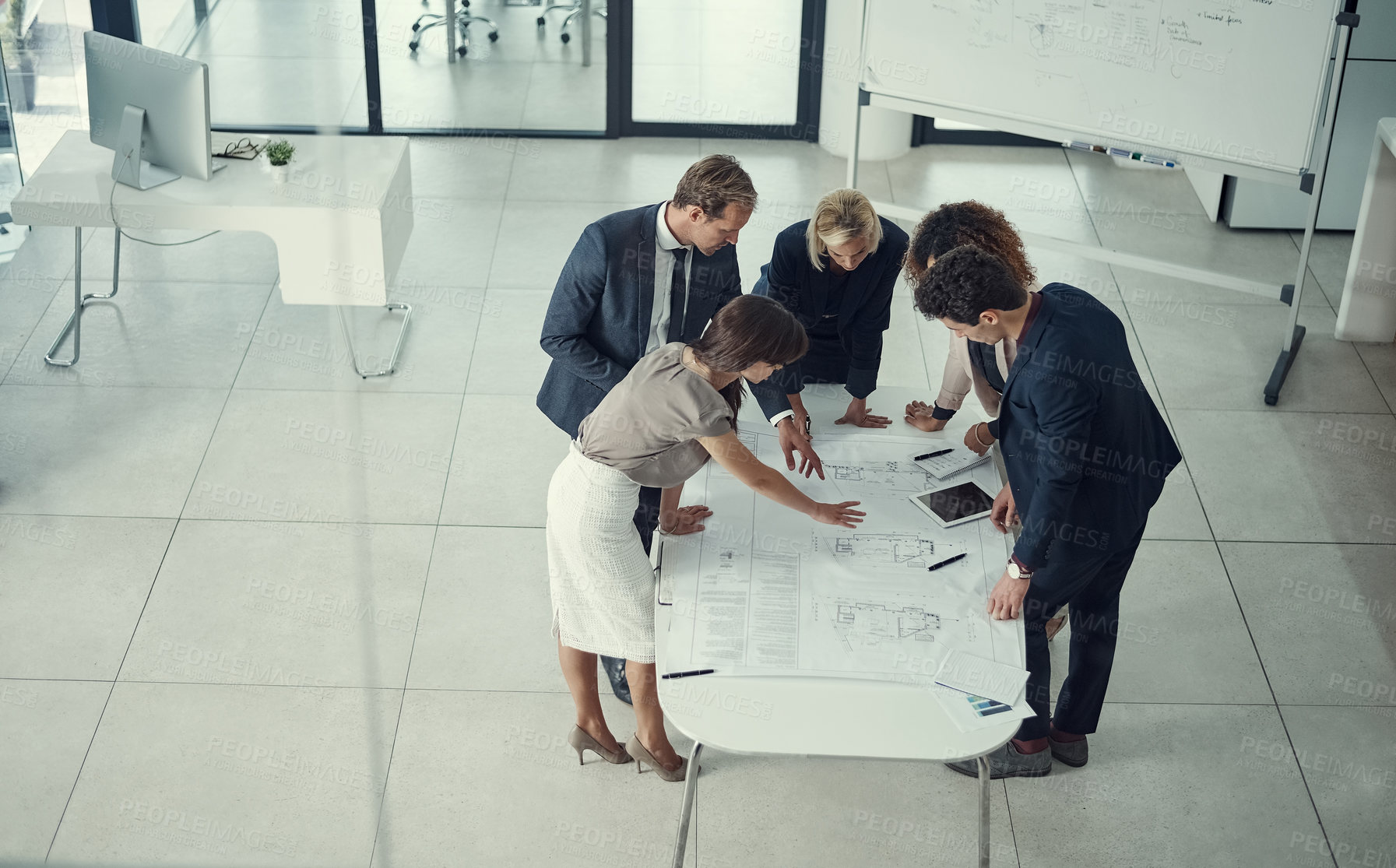 Buy stock photo Shot of a team of corporate architects collaborating on a plan in a modern office