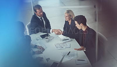 Buy stock photo Shot of two businessmen shaking hands during a meeting in a modern office