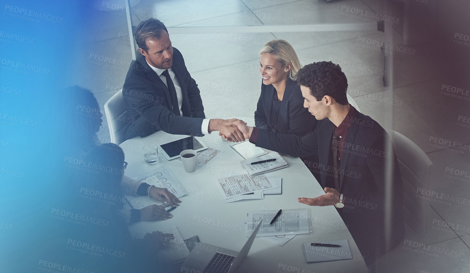 Buy stock photo Shot of two businessmen shaking hands during a meeting in a modern office