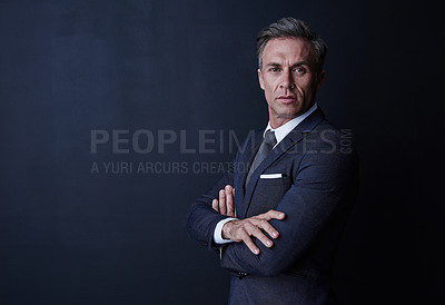 Buy stock photo Studio portrait of a confident and mature businessman standing against a dark background