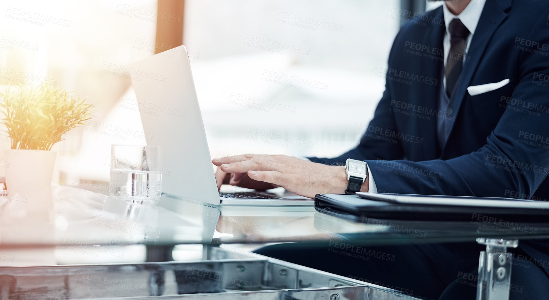 Buy stock photo Shot of an unidentifiable businessman working on a laptop in an office