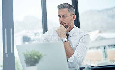 Buy stock photo Shot of a corporate businessman looking thoughtful while working in an office