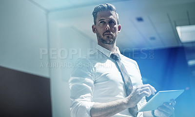 Buy stock photo Shot of a corporate businessman using a digital tablet in an office